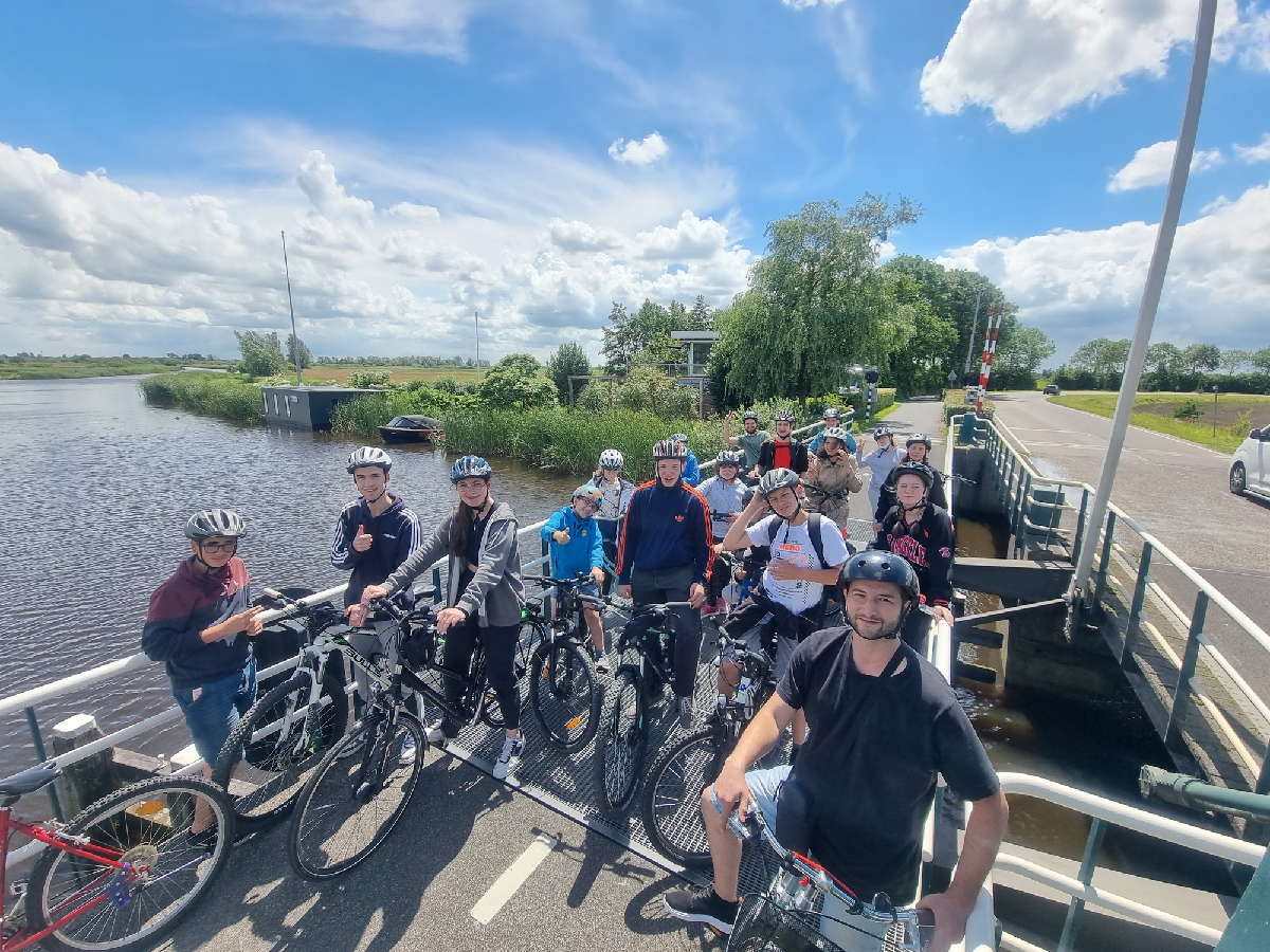 Gruppe Jugendlicher mit dem Fahrrad auf einer Brücke in Friesland/ NL